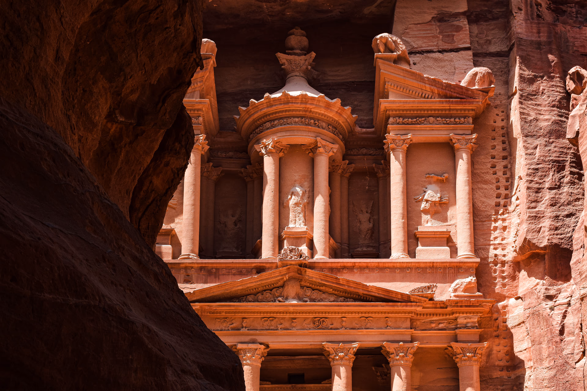 Carved façade of the Treasury framed by the narrow Siq canyon at Petra